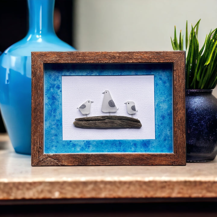Trois mouettes en verre de mer sur une photo en bois flotté avec un tapis aquarelle