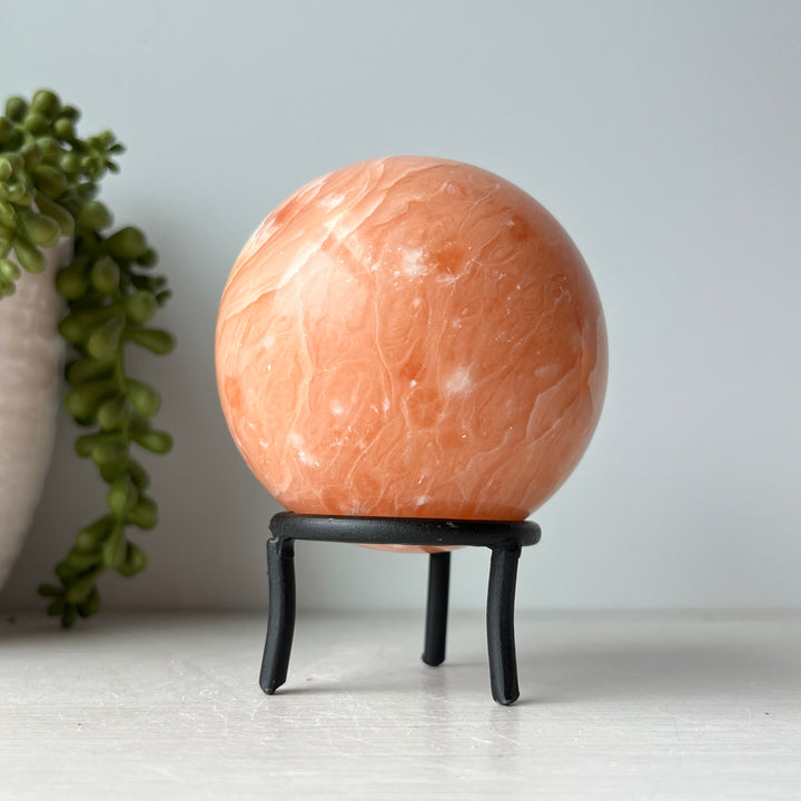 Orange Calcite Sphere on Metal Stand
